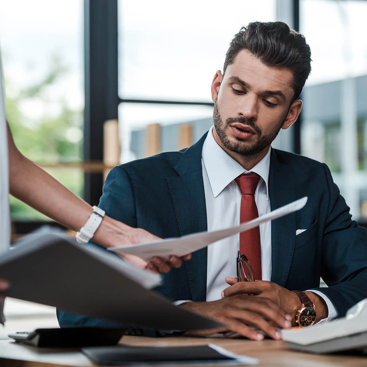 cropped view of woman holding folder and documents near bearded
